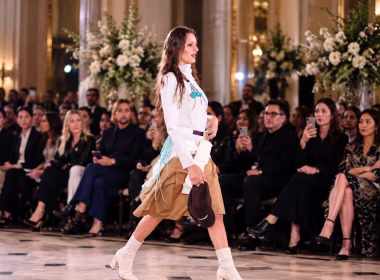 Model walking a fashion runway before an audience, illustrating the designers and creatives behind the best and worst dressed UK celebrities